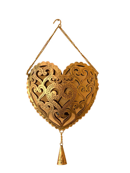 Decorative heart-shaped object with intricate patterns and a hanging chain on a white background