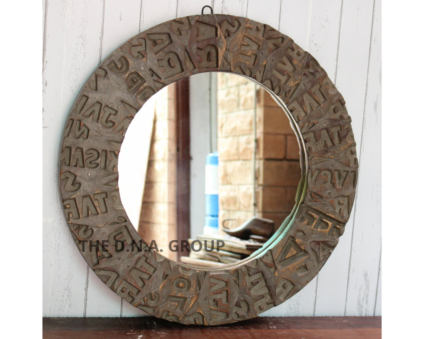 Round decorative mirror with textured frame on a wooden surface