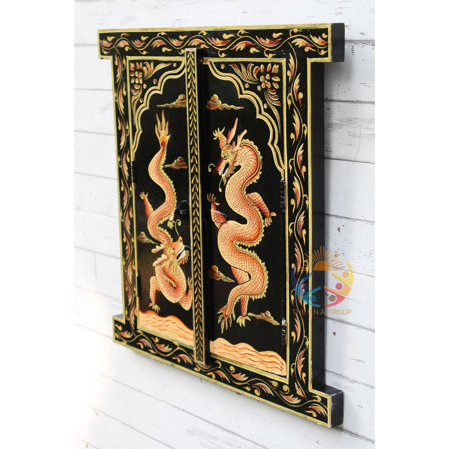 Decorative wall panel with dragon design on a black background, mounted on a white wooden wall.