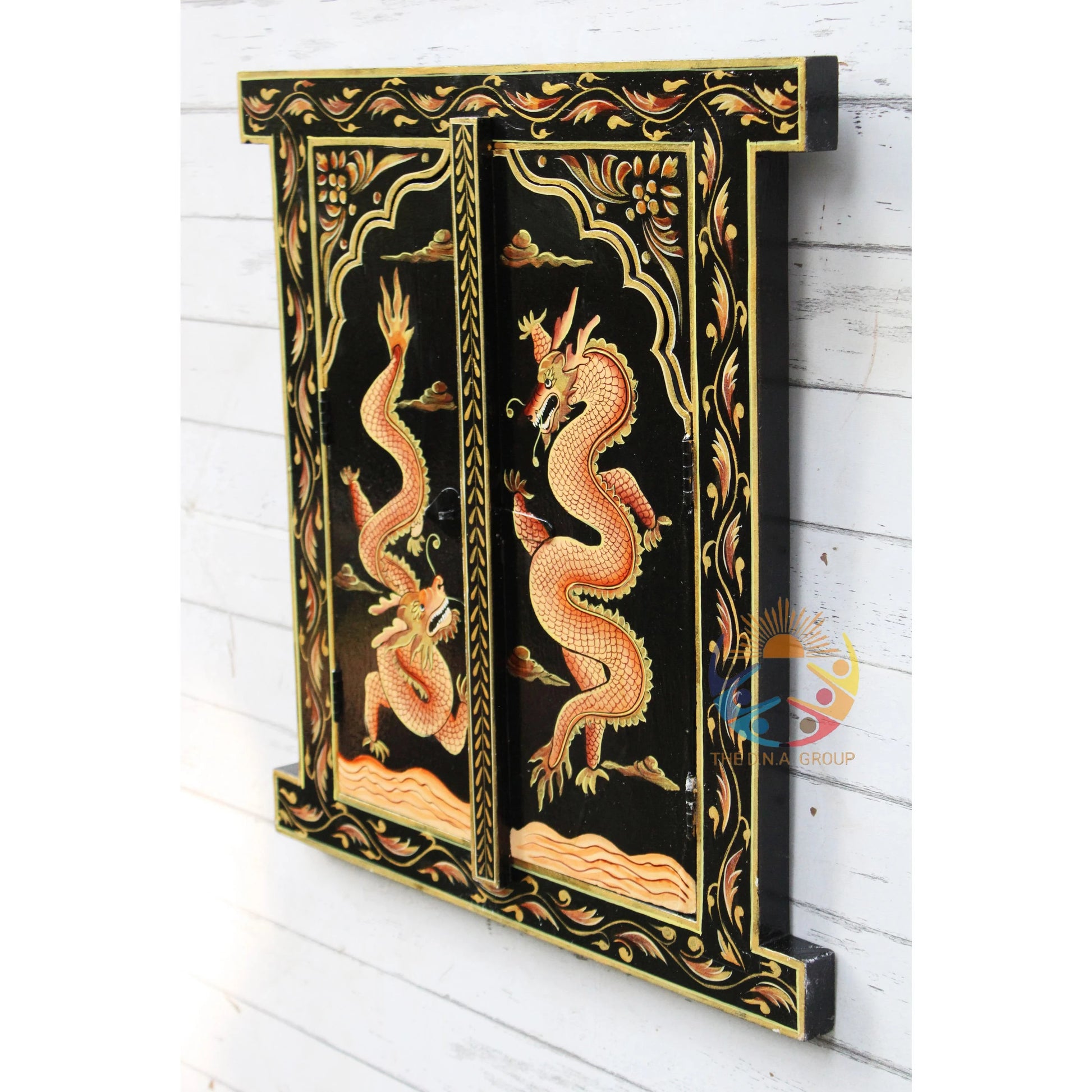 Decorative wall panel with dragon design on a black background, mounted on a white wooden wall.