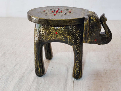 Decorative elephant-shaped stool with intricate designs on a light background