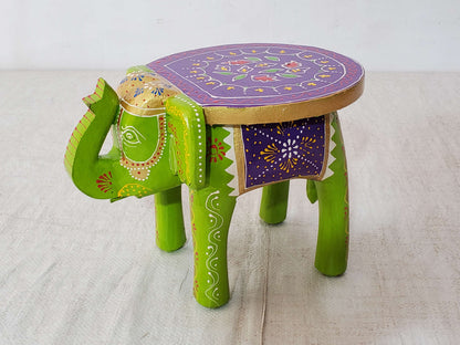 Decorative stool shaped like an elephant with a purple top on a light background