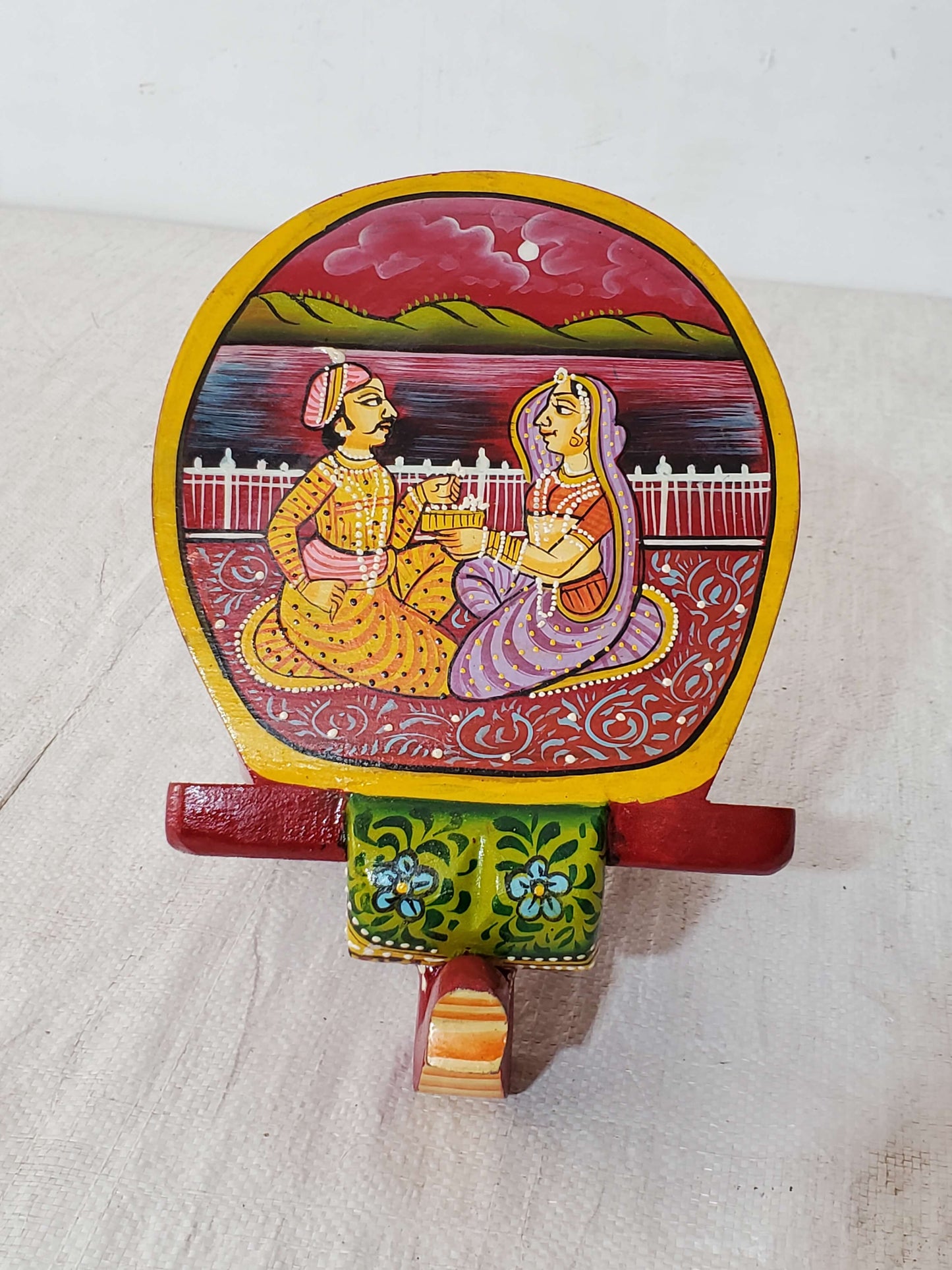 Decorative wall hook with a painted design of a couple on a white background