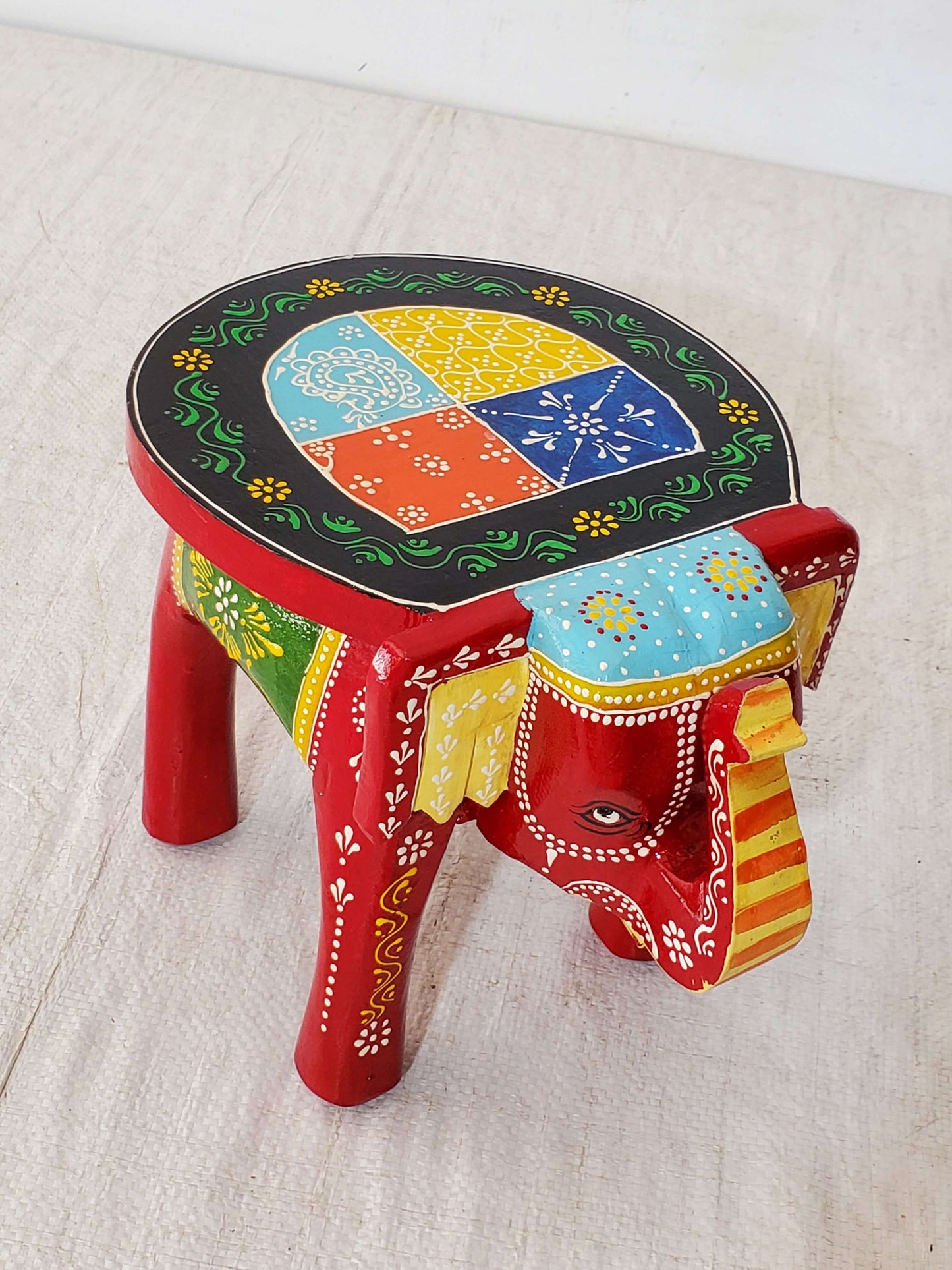 Colorful elephant-shaped stool with a geometric design on a light background