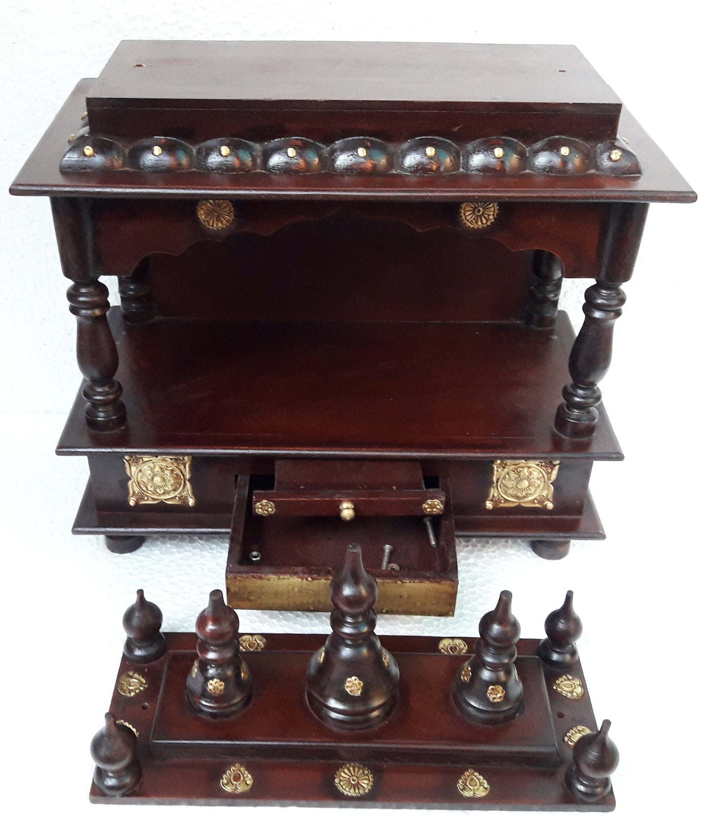 The INDIAN CRAFTS STORE Handcrafted Wooden Pooja Ghar Art Wooden features intricate carvings, ornate pillars, golden accents, a decorative top shelf, pull-out drawer, and detachable spire-adorned base—ideal for home decor or gifting.